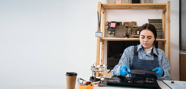Laptop disassembling at electronic repair shop or workshop. Woman engineer separating laptop case. Electronic renovation, business, occupation concept. Banner. copy space