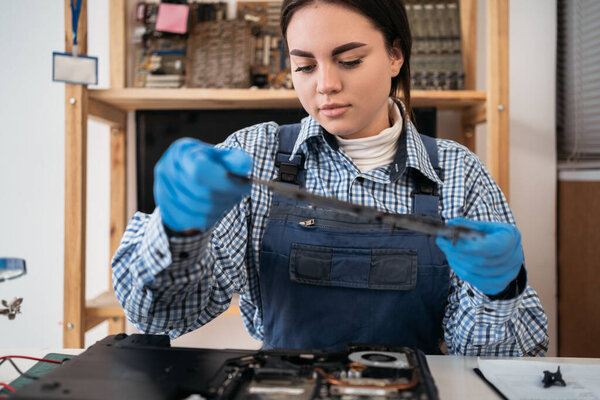 Repairman holding the laptop case for its repair and maintenance. Repair and maintenance of laptops. Selective focus. Close up