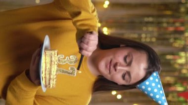 Doğum günü pastasında 37 numaralı mumları çakmakla yakan kadın. Gülümseyen kız doğum günü pastası tutuyor ve partide kameraya bakıyor. Bakış açısı. Dikey video