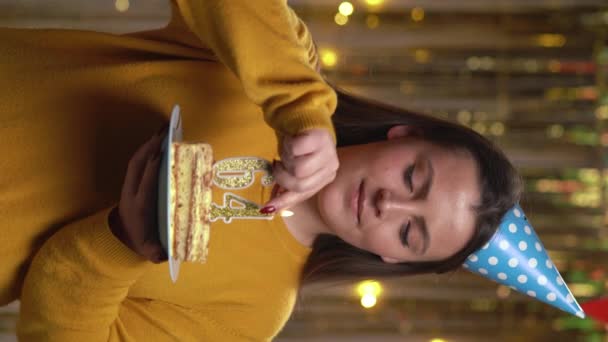 漂亮的年轻女人穿着毛衣 手里拿着生日蛋糕64号 金色蜡烛被打火机点着 庆祝生日和周年纪念日的概念 Pov 垂直录像 — 图库视频影像
