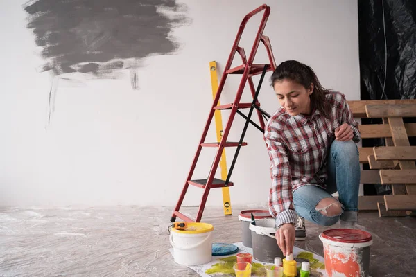 做家居装饰的妇女在地板上选择油漆罐和彩色调色板样品 复制空间 — 图库照片