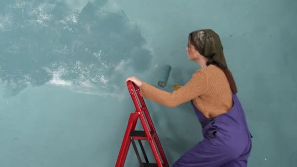 Piękna Młoda Kobieta Malująca Ścianę Pokoju Stojącym Drabinie Naprawiam Mieszkanie — Wideo stockowe