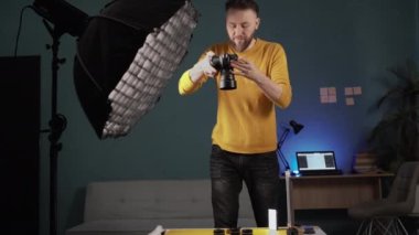 Evindeki stüdyoda çalışan bir fotoğrafçının masadaki güzellik ürünlerini çekmesi. Boşluğu kopyala