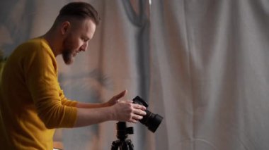 Ev stüdyosunda kamera kuran erkek fotoğrafçının yan görüntüsü. Boşluğu kopyala