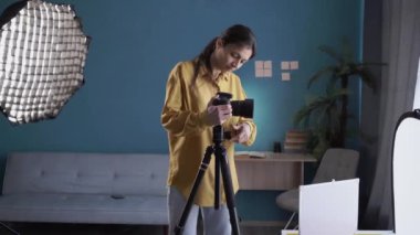 Yorgun kadın fotoğrafçı işten sonra evde fotoğraf stüdyosunda refleks kamerayla dinleniyor. Boşluğu kopyala