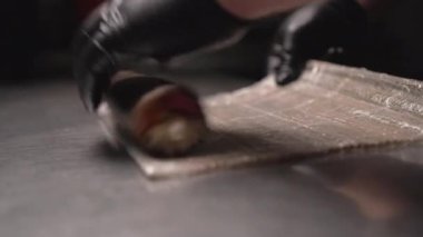 Erkek, Japon suşi ruloları yapar. Yakından yemek pişirir. Restoranda Japon yemeği. Boşluğu kopyala