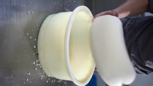 奶酪制造商穿着制服把奶酪做成模子 并在生产农场的奶酪轮上标注日期 奶酪的制作过程 垂直录像 — 图库视频影像