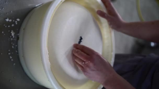 一位在奶酪工厂工作的男子的特写镜头 他把奶酪做成塑料模子 并把日期号码制作出来 近视男性的手 垂直录像 — 图库视频影像