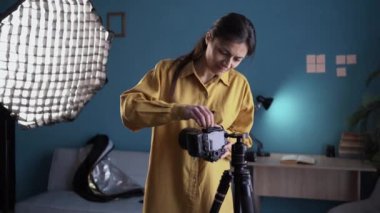 Profesyonel ekipmanlarla fotoğraf stüdyosunda. Kamerayı tripodun üzerinde tutan fotoğrafçı yumuşak kutular ve dağıtıcı ile fotoğraf çekmeye hazır. Boşluğu kopyala