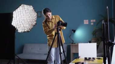 Kadın fotoğrafçı ev stüdyosuna kamera kuruyor. Fotoğraf stüdyosunda ışıklandırma ekipmanıyla moda çekiminde profesyonel fotoğrafçı. Boşluğu kopyala