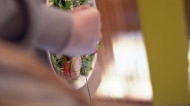 Tanınmayan bir kadın restoranda taze Sezar salatası yiyor. Yakın plan. Dikey video