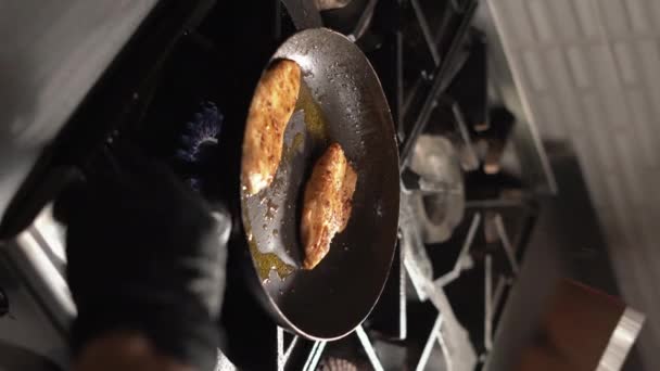 野菜油に揚げ鶏の胸肉のプロセス 鉄のキャスト 鋳鉄鍋で焙煎 閉めろ 垂直ビデオ — ストック動画