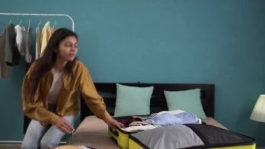 Yolculuğa hazır bir kadın bavulunu evde, yatakta kapatır. Seyahat ve deniz aşırı iş seyahati. Boşluğu kopyala