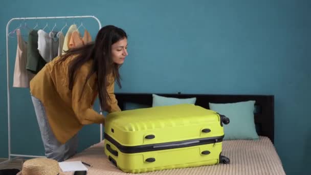 女性の観光客のベッドの屋内フラットコールタクシーで 旅行の準備ができて荷物を座っている スペースのコピー — ストック動画