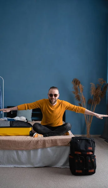 Joyful Young Man Traveler Imitating Airplane Sitting Bed Home Yellow — Stock Photo, Image