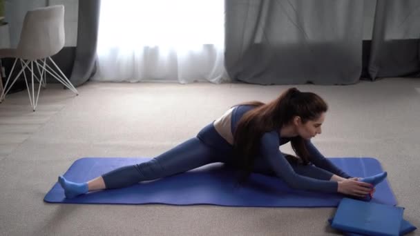 健康苗条的女人在健身垫上做热身运动 适合坐着伸懒腰的女人非常健康的女士在运动服运动 国内体育概念 — 图库视频影像