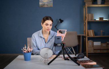 Vlogger dişisi göz farı paletini tavsiye ediyor. Nüfuzlu blogcu kadın canlı yayın kozmetik ürünleri değerlendirmesi yapıyor. Güzellik blogcusu kavramı