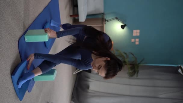 スポーティ若い女性はヨガを練習し アサナポーズをし 自宅で働きます 垂直ビデオ — ストック動画