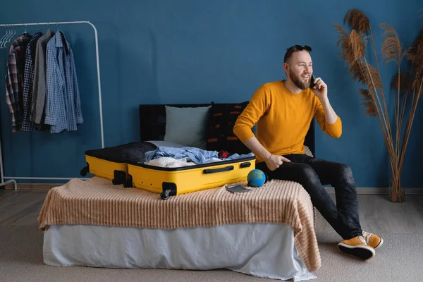 Genç Gezgin Açık Bavulla Yatakta Oturuyor Akıllı Telefondan Konuşuyor Evi — Stok fotoğraf