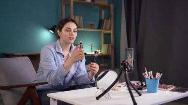 Sosyal medya nüfuzlu bir kadın makyaj ürünleri ve aksesuarlar öneriyor, farklı makyaj fırçaları gösteriyor. Video blogunu ev video stüdyosuna kaydet, güzellik blogcularının internet işi.