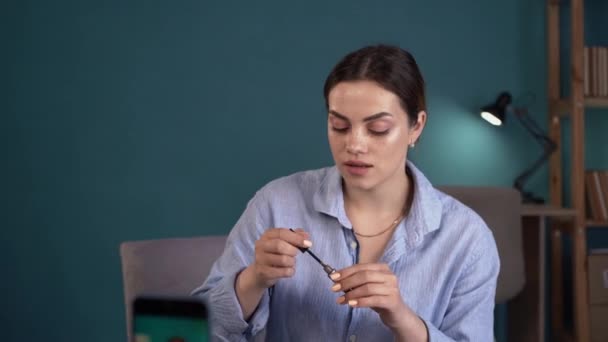 ホームインテリアの青いシャツのプロのメイクアップアーティストの女性の美しさのブロガー インフルエンサーレコードビデオレビュー携帯電話用新しい眉ケア化粧品 — ストック動画