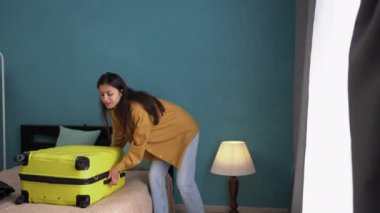 Kadın turistler bavullarını boşaltıyor, otel odasında bavullarını boşaltıyor. Boşluğu kopyala