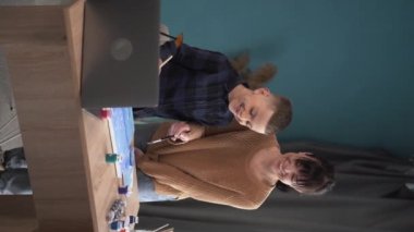 Mutlu bir aile. Anne ve oğlu evde günlük kıyafetlerle tuvale akrilik boyalarla resim yapıyorlar. İlham, eğitim ve sanat konsepti. Dikey görünüm. Boşluğu kopyala.