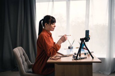 Kafkasyalı kadın akrilik boya ile resim yapmayı öğreniyor. Hobi ve eğlence çevrimiçi kurs konsepti. yakın plan portre