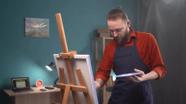Konzentrierter Mann Schürze Malt Einem Hellen Kunstatelier Hause Ein Bild — Stockvideo