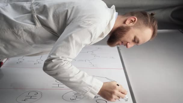 身穿白衣的白人男性千年化学老师站在黑板前 用化学公式写下了一个带有标记的等式 垂直视频 — 图库视频影像
