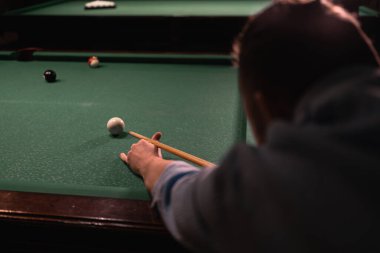 Bilardo oyununun bir parçası devam ediyor. Amerikan bilardosu oynayan yakışıklı adam. Bilardo sporu konsepti.