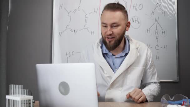 一位千年化学老师在家里的网络摄像头上给我们上了一课 一位博主在一个装有化学配方的白板的背景下现场直播 — 图库视频影像