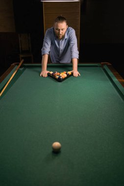 Yeşil kumaş üzerinde bilardo oyunu. Milenyum adamı çok renkli bilardo toplarını sayılı bir üçgen haline getiriyor, bilardo masasında bir üçgen. Boşluğu kopyala