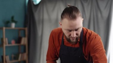 Ev bitkileri yenileniyor. Yakışıklı adam evdeki yeni çömleğe bitkiler naklediyor, kara toprak koyuyor. Bahar bitkisi bakımı.