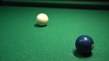 Bilardo salonundaki geniş bir masada bilardo toplarını kovalayan erkeklerin yakın çekimi. Bilardo spor konsepti