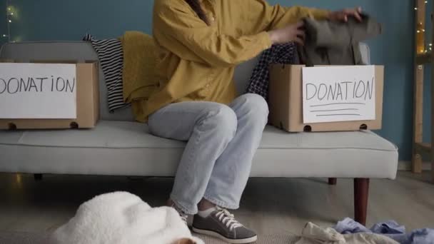 Молодая Женщина Коробками Пожертвований Дома Коробка Пожертвований Бедных Одеждой Диване — стоковое видео
