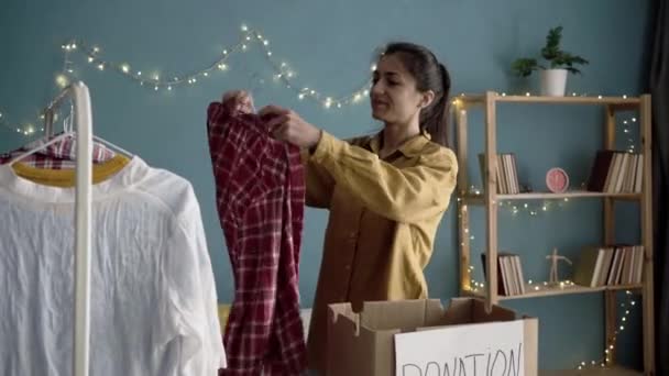 Jonge Mooie Vrouw Sorteren Garderobe Binnen Thuis Verpakking Donatie Dozen — Stockvideo