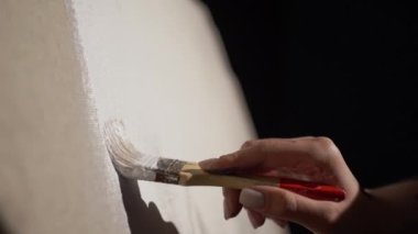 Bir ressamın el resmi beyaz boya ve sanat arkaplanlı tuvale bir soyutlama çizer. Boşluğu kopyala