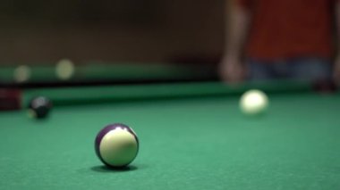Erkek eller bilardo odasında geniş yeşil bir masada bilardo toplarını kovalarlar. Bilardo konsepti. Yakın plan.