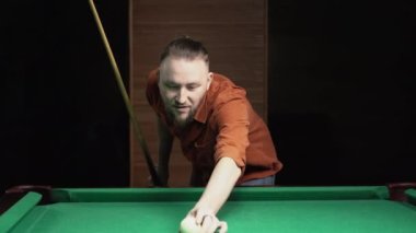 Bilardo konsepti. Bilardo oynayan bir adamın yakın plan fotoğrafı. Renkli topa ıstakayla vuruyor. Boşluğu kopyala