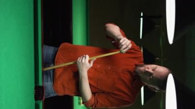 Yakışıklı adam bilardo ıstakasını tebeşirle hazırlıyor. Bilardo konsepti. Dikey video