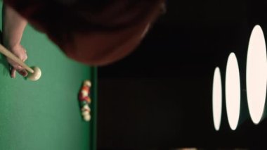 Adam bilardo masasında bilardo piramidine çarpıyor. Bilardo sporu konsepti. Dikey video