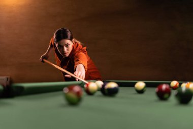 Masadaki bilardo topunu işaret eden bir kadın eli. Bilardo konsepti