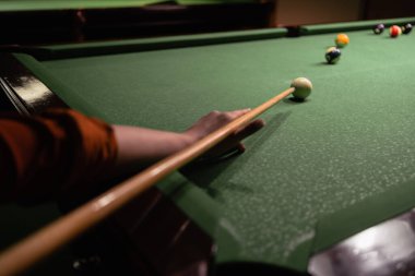 Bilardo oynuyorum. Masada bilardo topuna nişan almış bir kadın eli. Bilardo sporu konsepti.