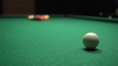 Yeşil bir masada bilardo topu üçgenine vuran bir ıstaka çubuğunun yakın çekimi. Bilardo sporu konsepti.