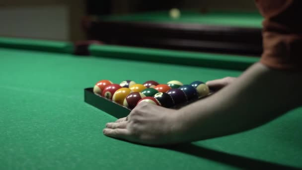 プールテーブルの三角形のビリヤードボールを持つ男 ゲームやスポーツ — ストック動画