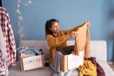 Kadınlar konsept bağış için kıyafetlerini kutuya koyup geri dönüşüm için tekrar kullanırlar. Bağış ve yardım konsepti