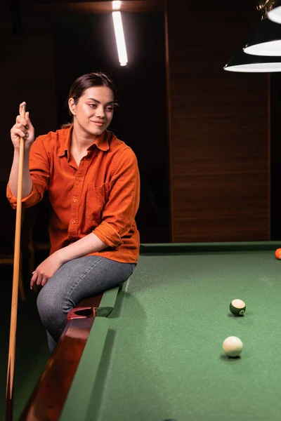 young woman playing billiards alone relaxing in a club. Playing billiards concept