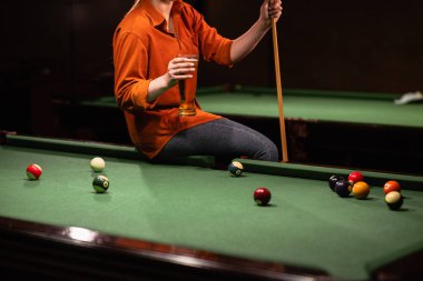 Bilardo masasının yanında bira içen genç ve güzel bir kızın görüntüsü. Boşluğu kopyala