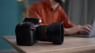 Kameralı ve dizüstü bilgisayarlı fotoğrafçıların ellerini yakın çekimde evdeki bir masaya aktararak dijital kameraya odaklanıyorlar. Makro görünüm